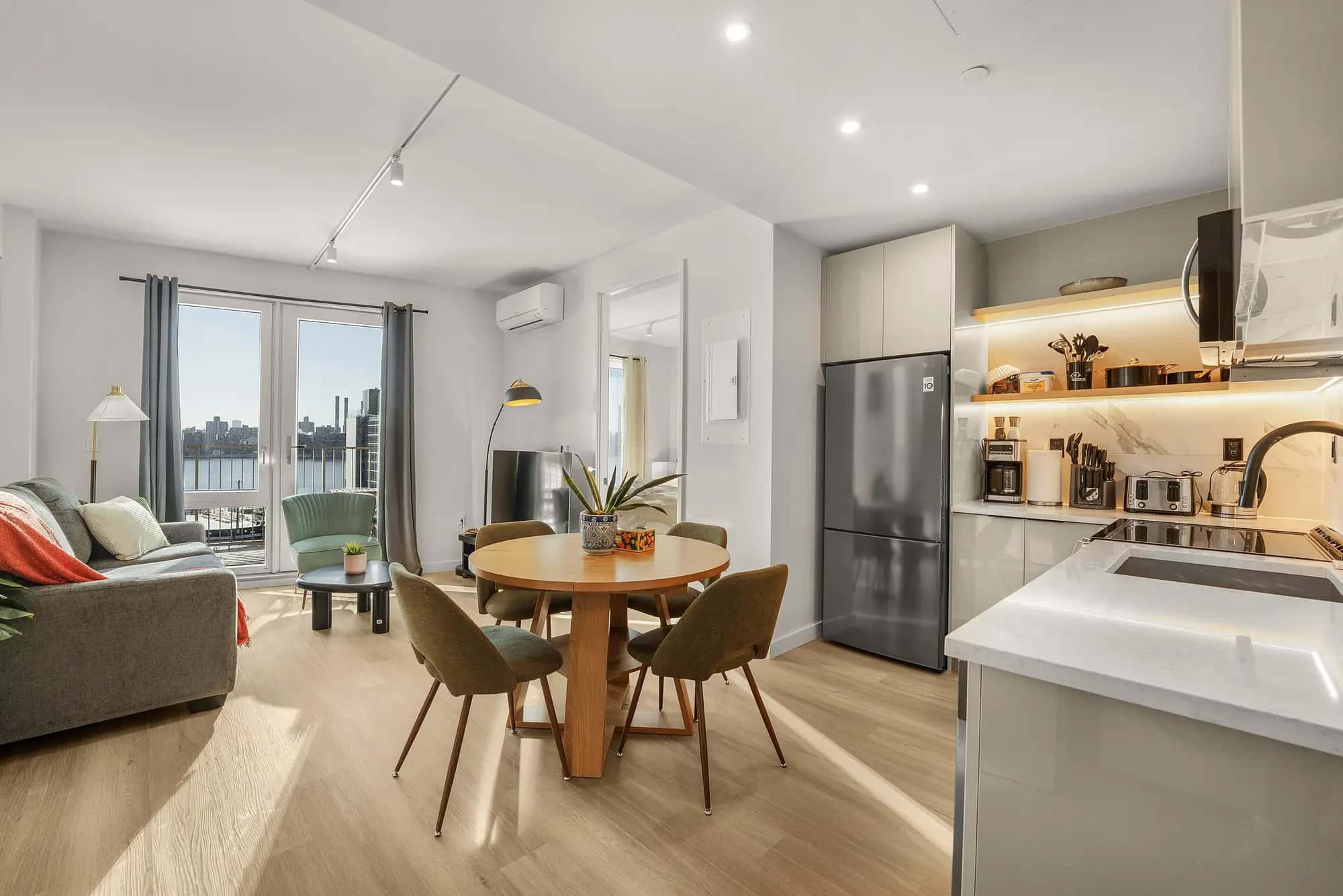 Furnished living and dining room with a New York city view in a Waypost Brooklyn residence