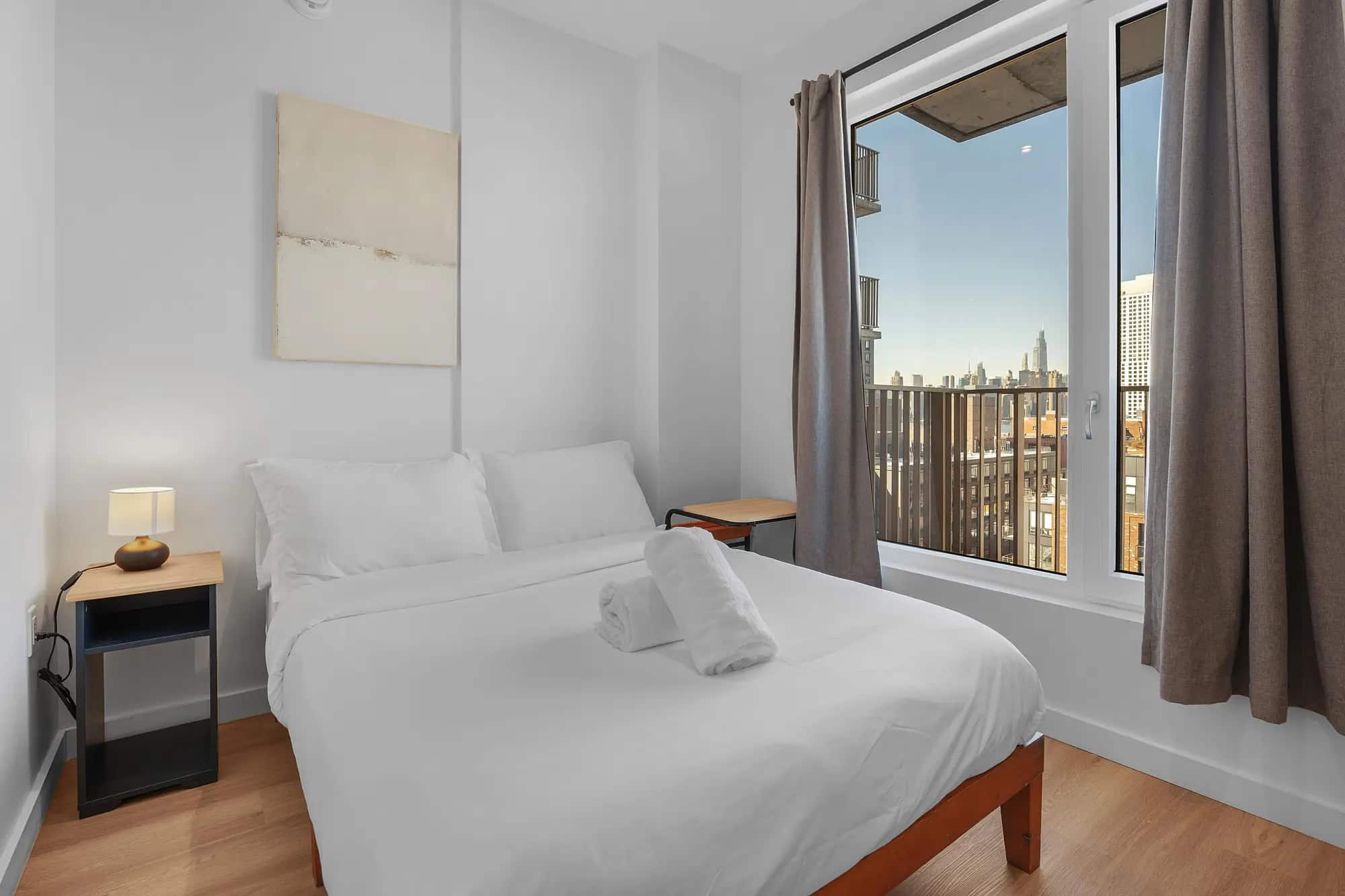 Furnished bedroom with a New York skyline view in a Waypost Brooklyn residence