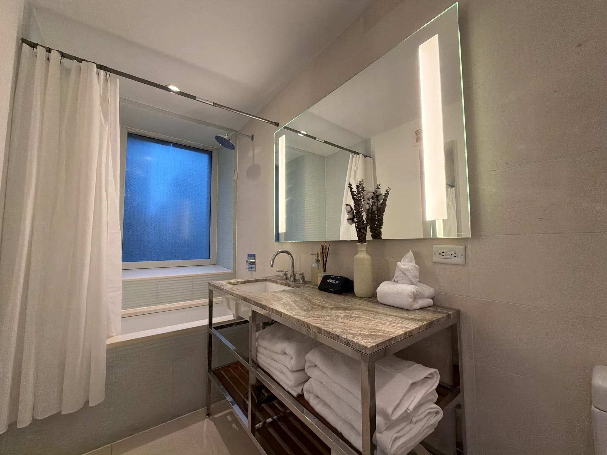 Bathroom vanity with folded towels and a shower curtain