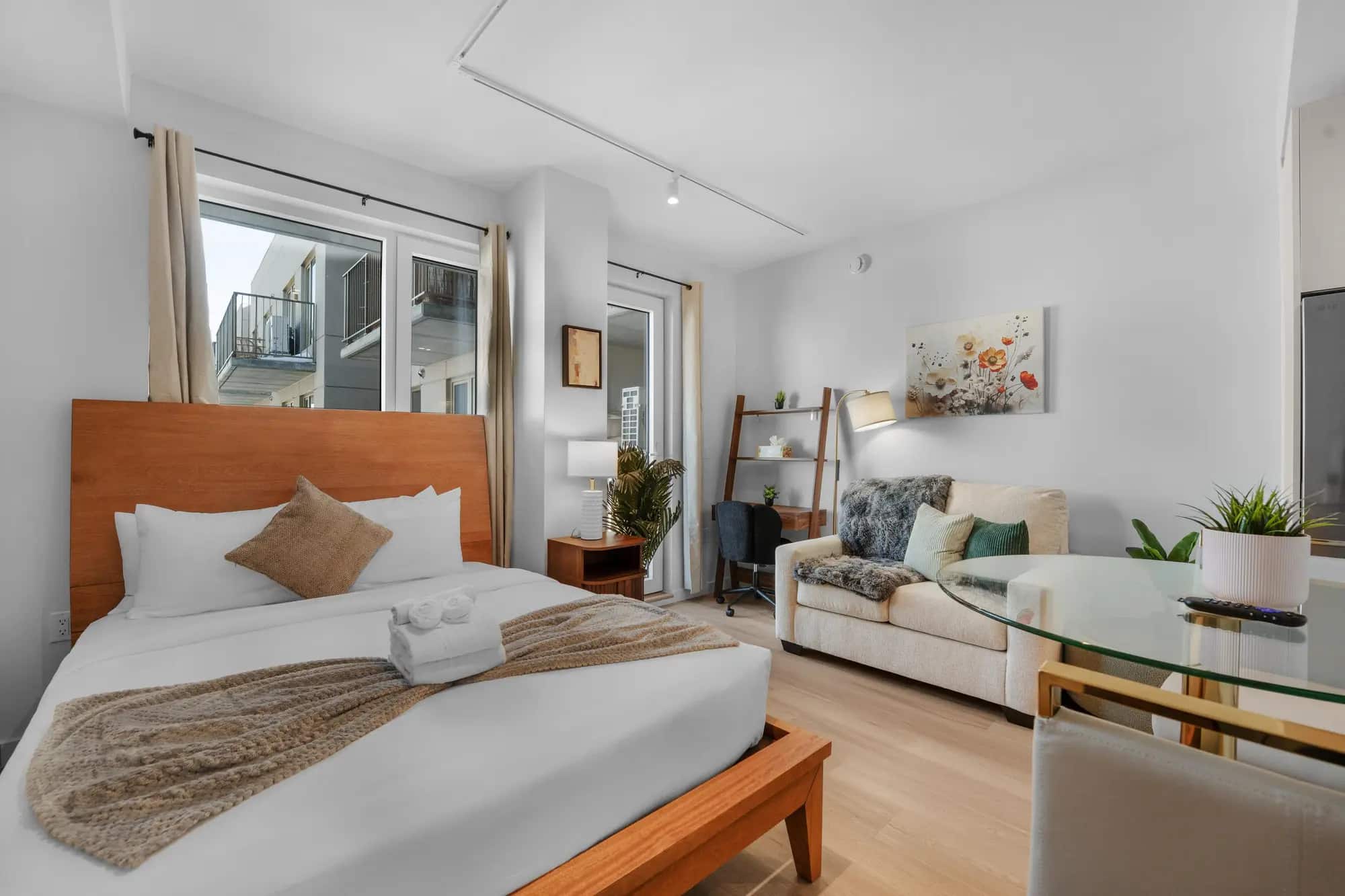 Furnished studio with a bed, sofa, and work area in a Waypost Brooklyn residence