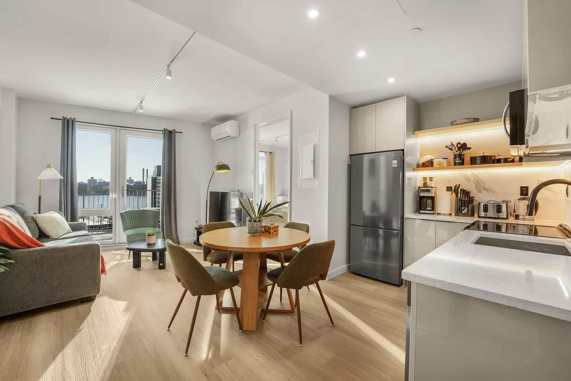 Furnished living and dining room with a New York city view in a Waypost Brooklyn residence